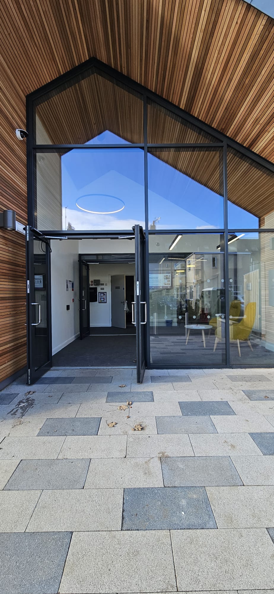 Modern cedar-clad community centre with full-height aluminium glazed entrance and twin doors