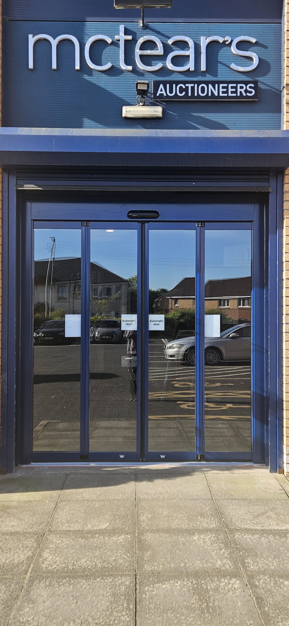 Four-leaf blue automatic sliding entrance doors at McTear's Auctioneers, Glasgow